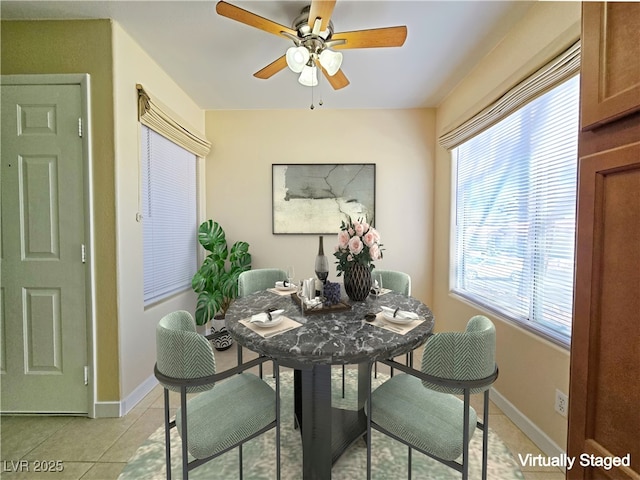 dining area featuring light tile patterned floors, baseboards, and ceiling fan