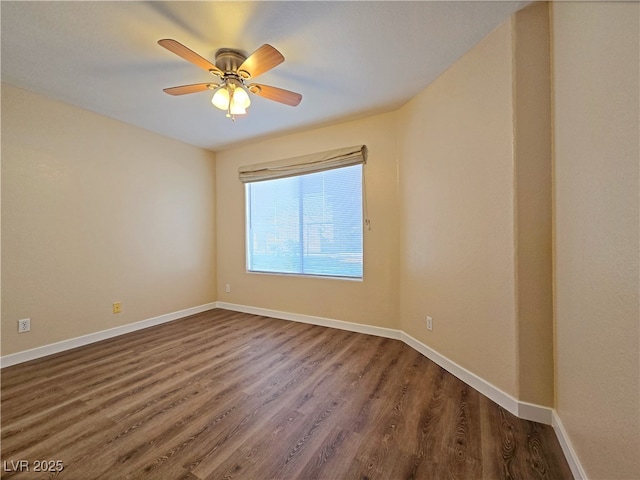 unfurnished room with baseboards, dark wood-style floors, and a ceiling fan