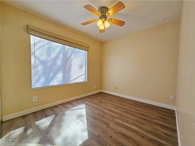 spare room with a wealth of natural light, baseboards, and dark wood-type flooring