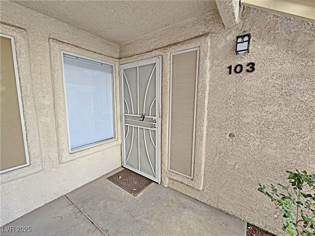 view of exterior entry with stucco siding