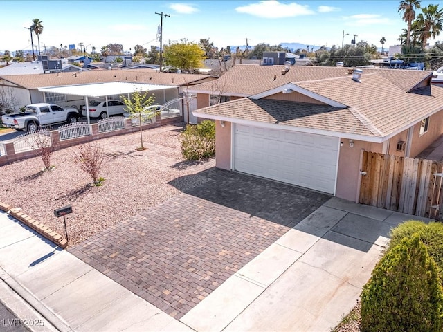 ranch-style home with stucco siding, driveway, roof with shingles, and fence