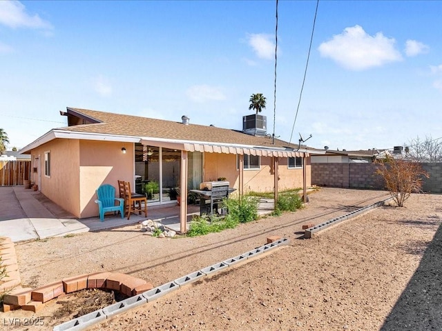 back of house featuring roof with shingles, a fenced backyard, stucco siding, central air condition unit, and a patio area