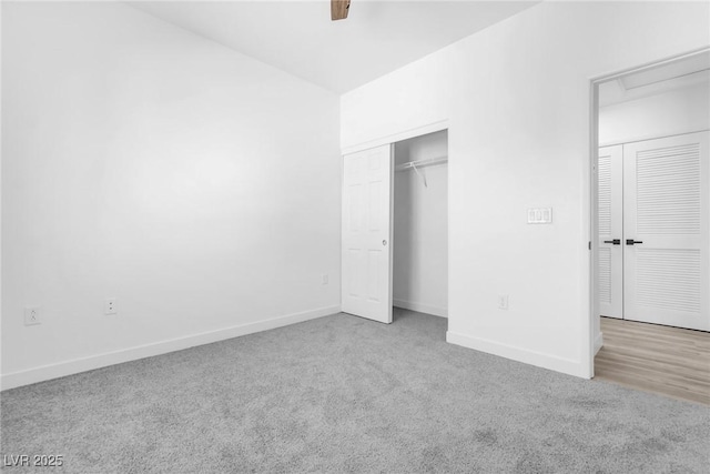 unfurnished bedroom with a closet, carpet flooring, a ceiling fan, and baseboards