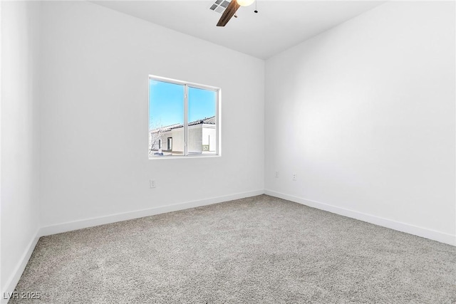 carpeted empty room with visible vents, a ceiling fan, and baseboards