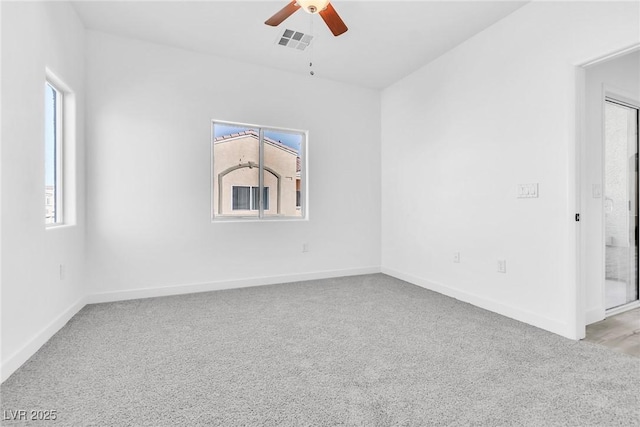 unfurnished room featuring visible vents, baseboards, light colored carpet, and ceiling fan