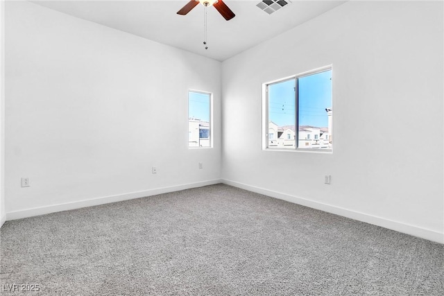 empty room with visible vents, baseboards, carpet, and a ceiling fan