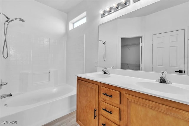 full bathroom with a sink, shower / bath combination, wood finished floors, and double vanity