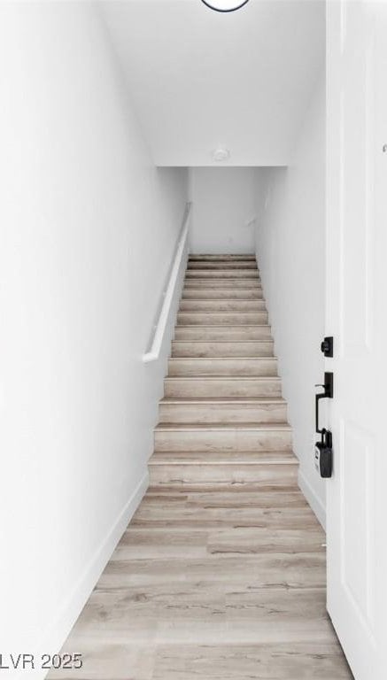 stairway featuring baseboards and wood finished floors