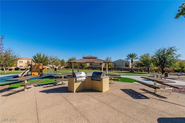 view of property's community featuring a gazebo, an outdoor kitchen, playground community, and a yard