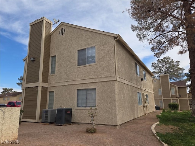 view of property exterior with cooling unit and stucco siding