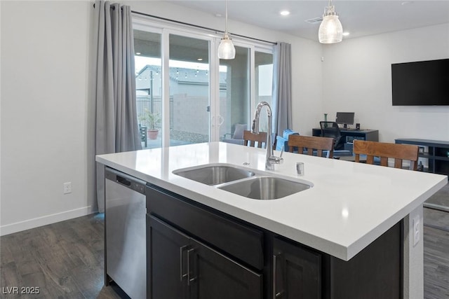 kitchen with an island with sink, a sink, decorative light fixtures, dark wood finished floors, and dishwasher