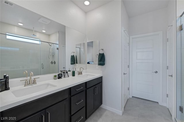 bathroom featuring double vanity, visible vents, a shower stall, and a sink