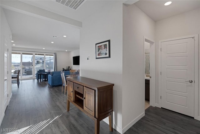 hallway with recessed lighting, visible vents, baseboards, and dark wood-style flooring