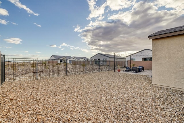 view of yard featuring a patio area, a residential view, and fence