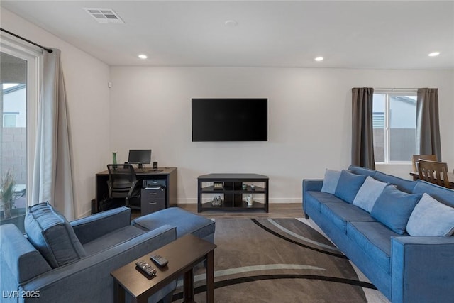 living area with wood finished floors, recessed lighting, visible vents, and baseboards