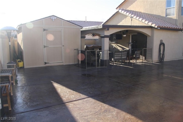 view of patio featuring an outbuilding and a storage unit