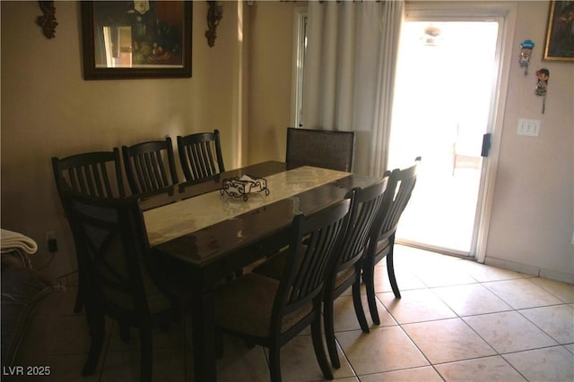 dining space featuring light tile patterned floors and baseboards