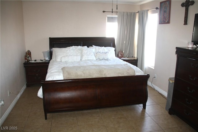 tiled bedroom featuring baseboards and multiple windows