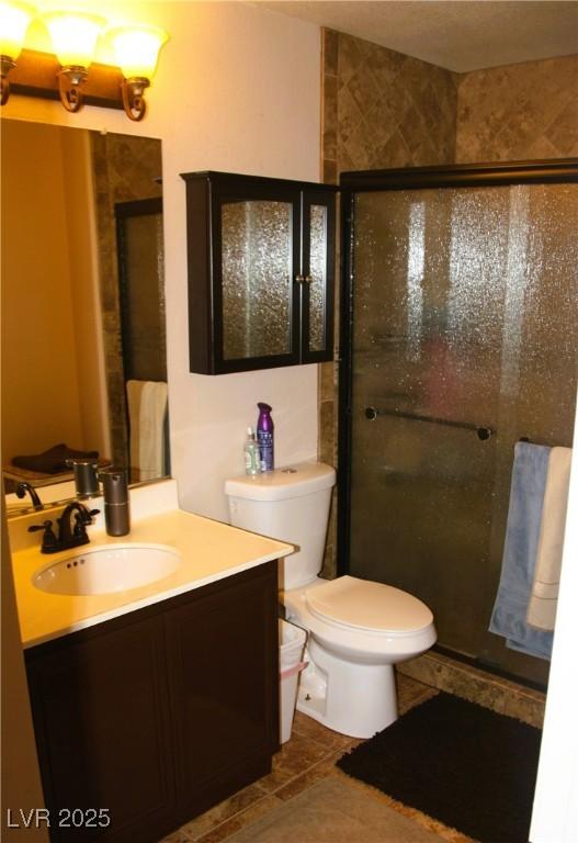 full bathroom featuring vanity, toilet, and a stall shower