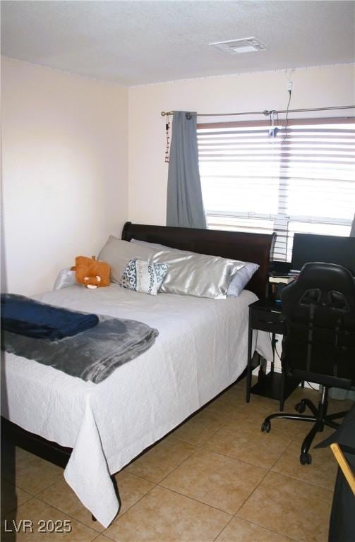 bedroom featuring multiple windows, visible vents, and light tile patterned floors