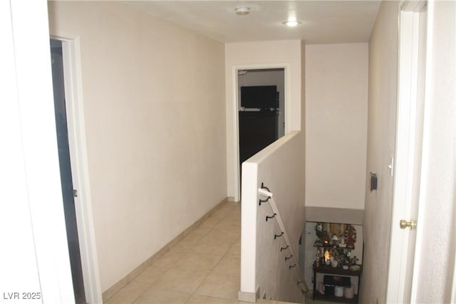 corridor with light tile patterned floors and baseboards