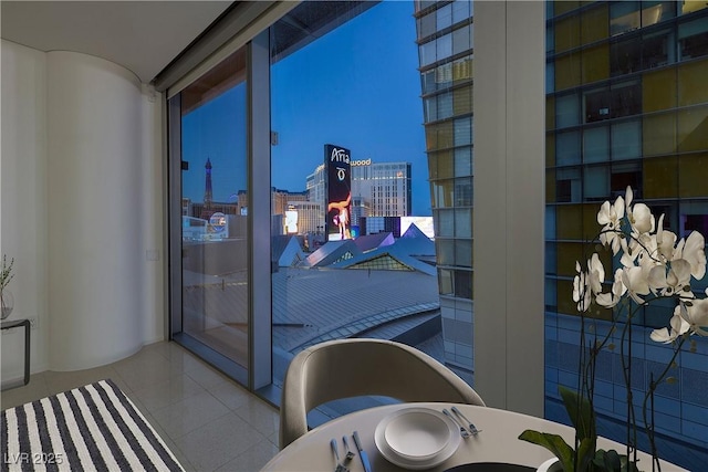 interior space featuring tile patterned flooring, a notable chandelier, a view of city, and a freestanding tub