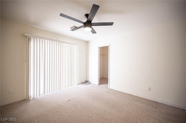 carpeted spare room featuring visible vents and a ceiling fan