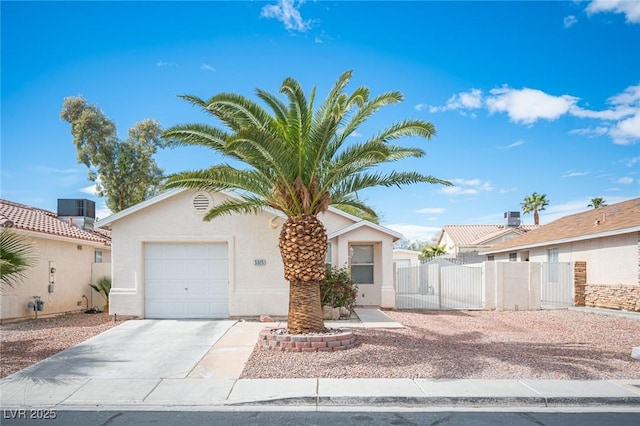 view of front of home with a gate, driveway, stucco siding, a garage, and central air condition unit