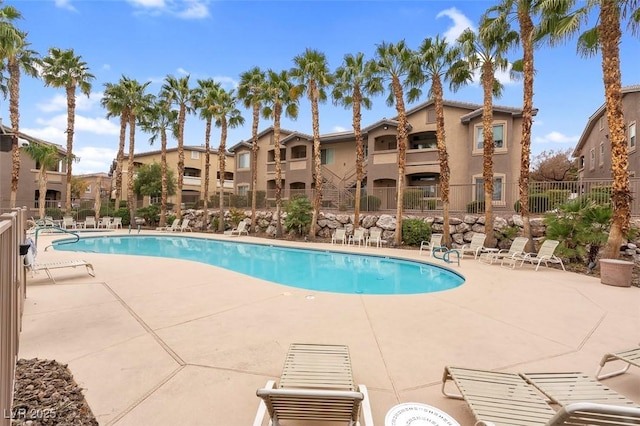 pool featuring a residential view, a patio, and fence