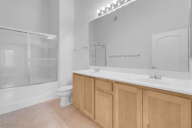 bathroom with double vanity, tile patterned floors, toilet, and a sink