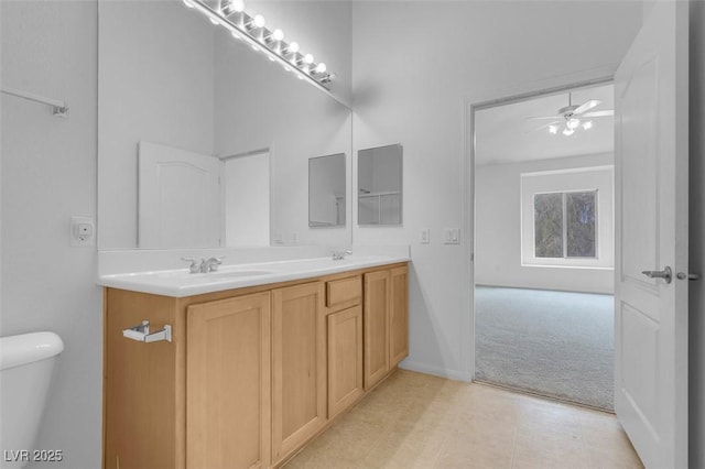 full bathroom with double vanity, toilet, ceiling fan, and a sink