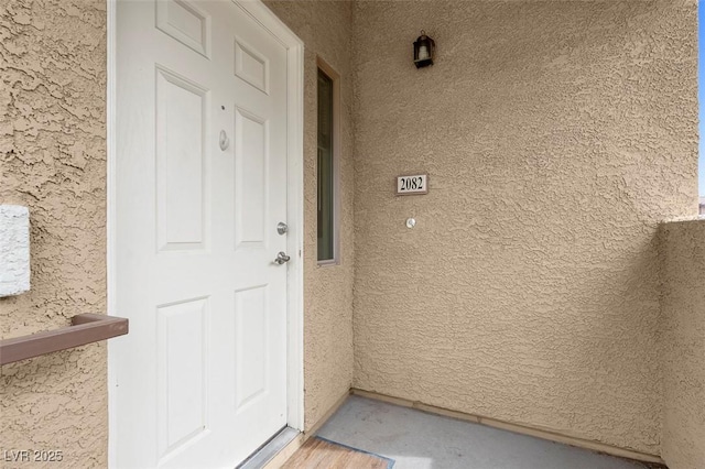 property entrance with stucco siding