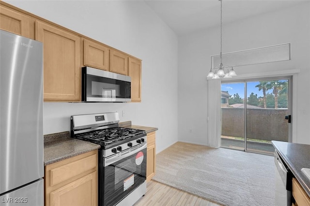 kitchen featuring dark countertops, light brown cabinets, and stainless steel appliances