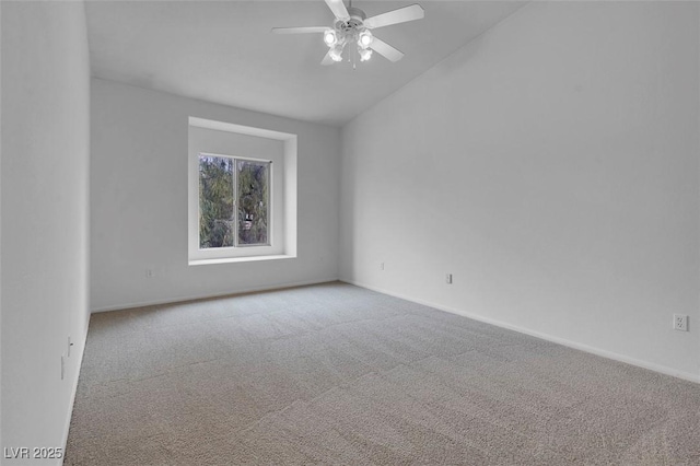 carpeted empty room with baseboards, lofted ceiling, and a ceiling fan