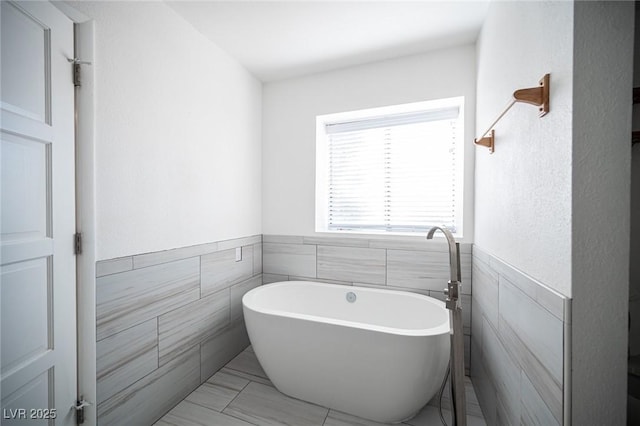 3369 Milenko Dr, Las Vegas, NV 89121 - bathroom with tile walls, a soaking tub, and wainscoting