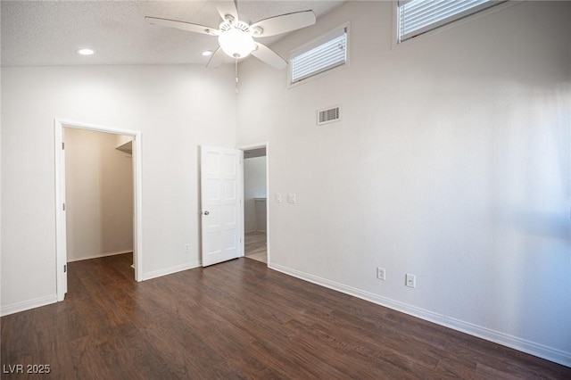 3369 Milenko Dr, Las Vegas, NV 89121 - unfurnished bedroom with a walk in closet, baseboards, dark wood-style flooring, high vaulted ceiling, and a ceiling fan