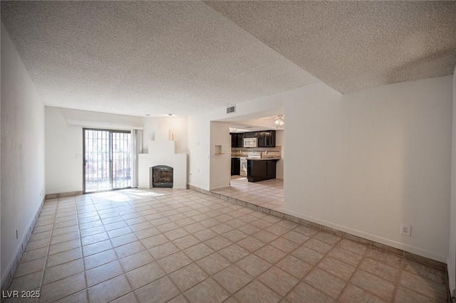 3369 Milenko Dr, Las Vegas, NV 89121 - unfurnished living room featuring a textured ceiling, a fireplace, light tile patterned flooring, and baseboards