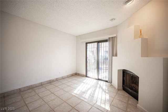3369 Milenko Dr, Las Vegas, NV 89121 - unfurnished living room featuring a textured ceiling, a fireplace, and light tile patterned floors