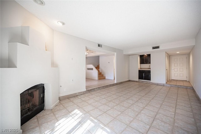 3369 Milenko Dr, Las Vegas, NV 89121 - unfurnished living room featuring a fireplace, stairway, and baseboards