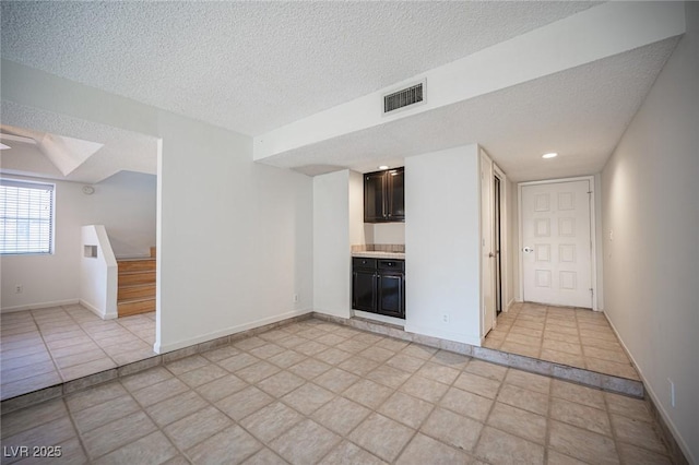 3369 Milenko Dr, Las Vegas, NV 89121 - empty room featuring a textured ceiling, stairs, and baseboards