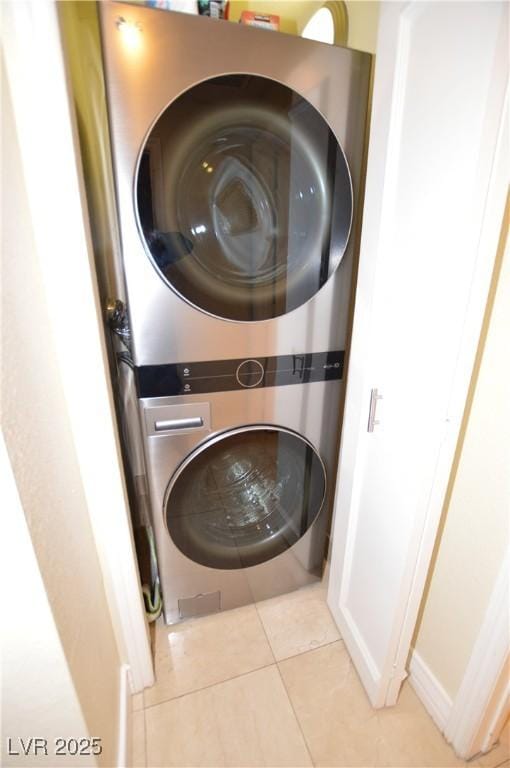 washroom featuring light tile patterned floors and stacked washer and clothes dryer