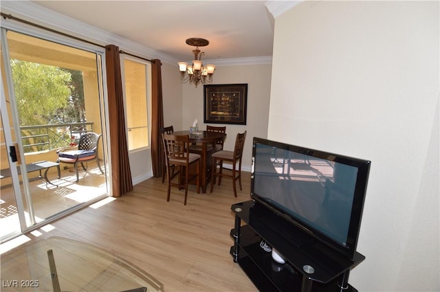 dining area featuring light wood-type flooring, baseboards, a notable chandelier, and crown molding