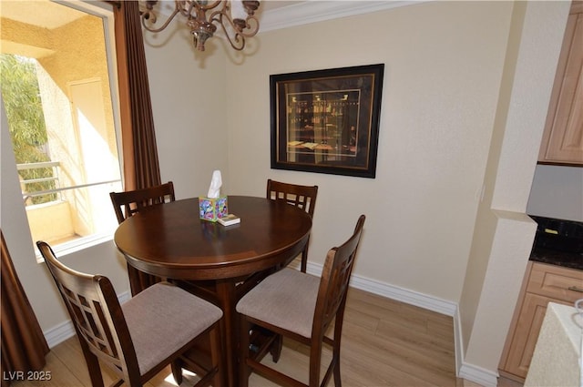 dining room with baseboards, light wood finished floors, and ornamental molding