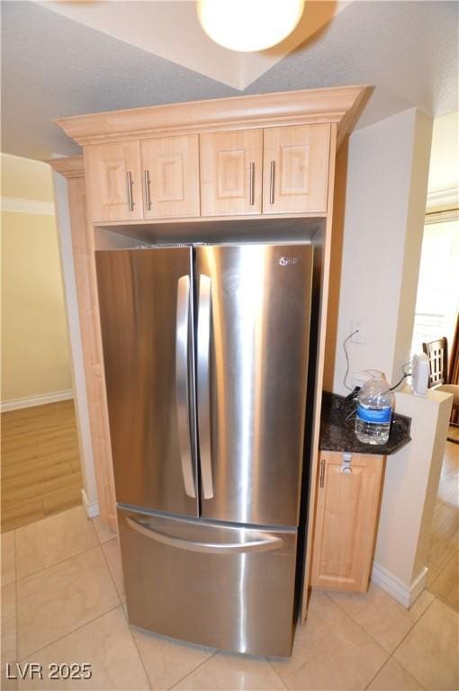 interior details with light brown cabinetry and freestanding refrigerator