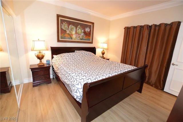 bedroom featuring baseboards, crown molding, and light wood finished floors