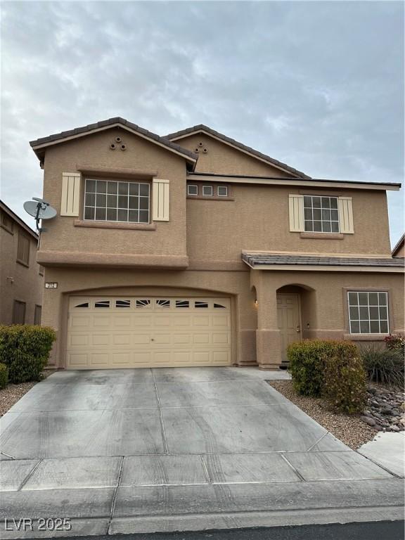 traditional home featuring stucco siding, driveway, and a garage