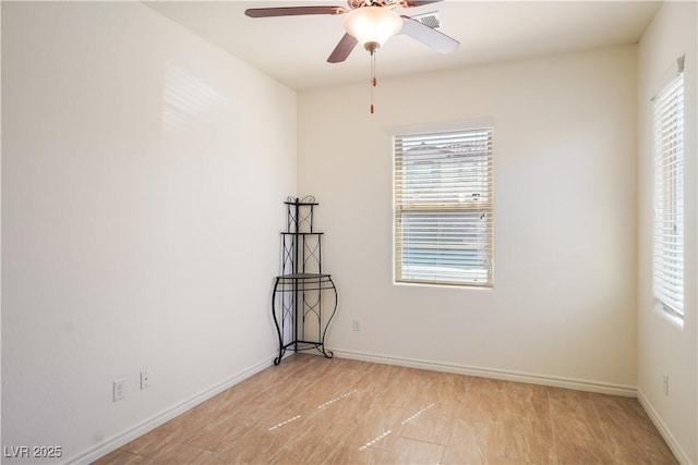 empty room featuring a healthy amount of sunlight, a ceiling fan, and baseboards