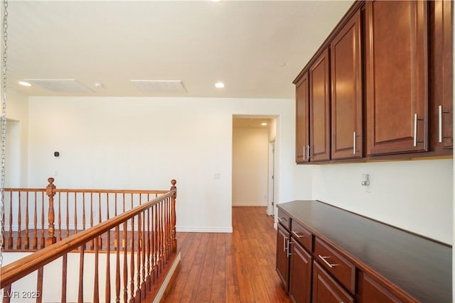 corridor with an upstairs landing, dark wood-style floors, recessed lighting, and baseboards