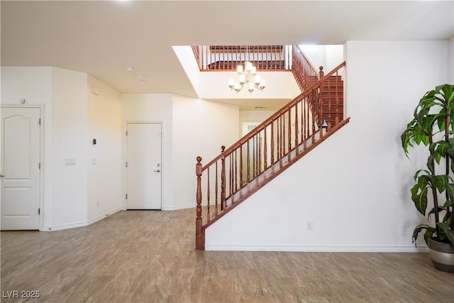 interior space with stairs, wood finished floors, baseboards, and a chandelier