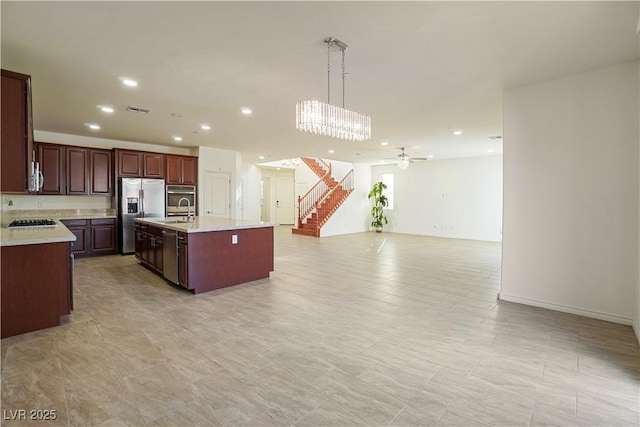 kitchen with visible vents, a sink, light countertops, appliances with stainless steel finishes, and open floor plan